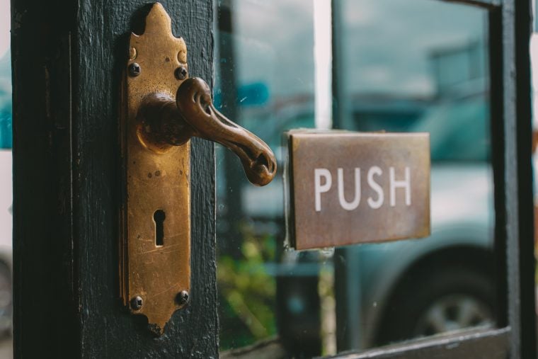 Photograph of a door with a sign that reads PUSH