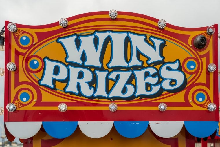 Photograph of a carnival sign that reads WIN PRIZES